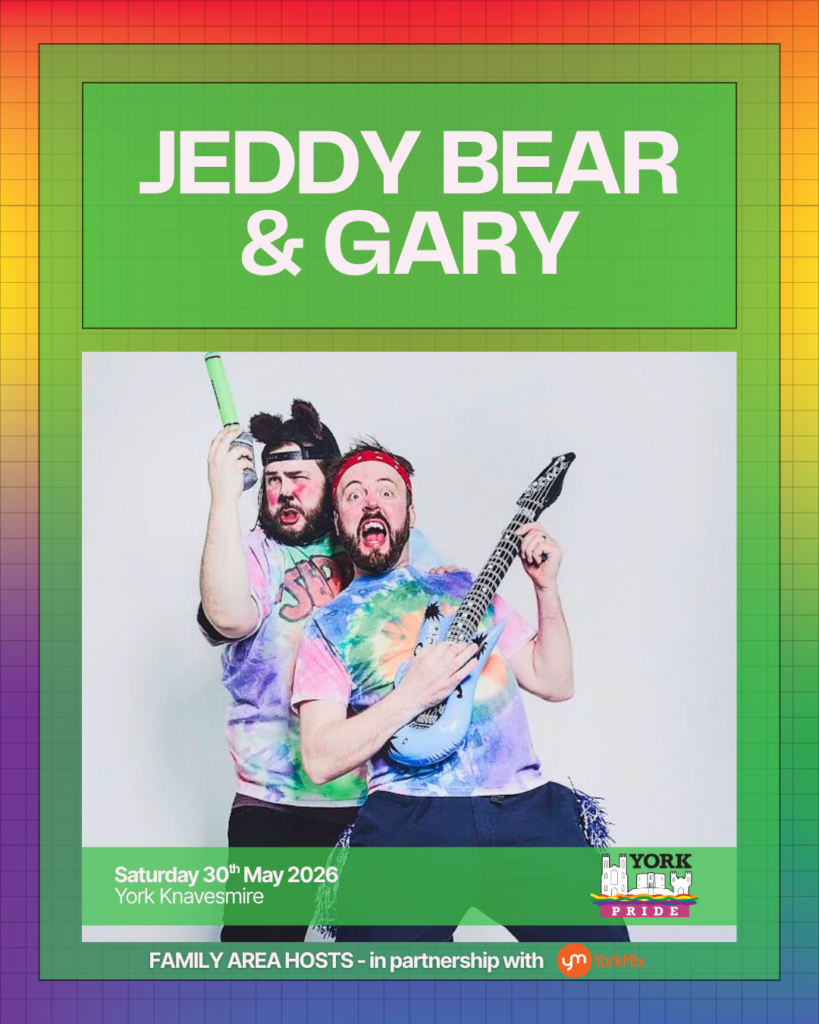 I'm unable to say who these people are, but here's suitable alt text:Two people in colourful tie-dye shirts celebrate at York Pride, holding fun props and posing energetically.